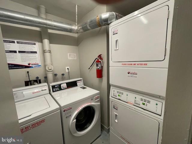 community laundry room with stacked washer / drying machine and washing machine and clothes dryer