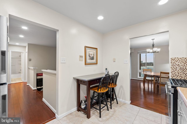 dining room with recessed lighting, baseboards, a notable chandelier, and light tile patterned floors