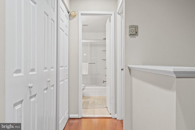 corridor with visible vents and wood finished floors