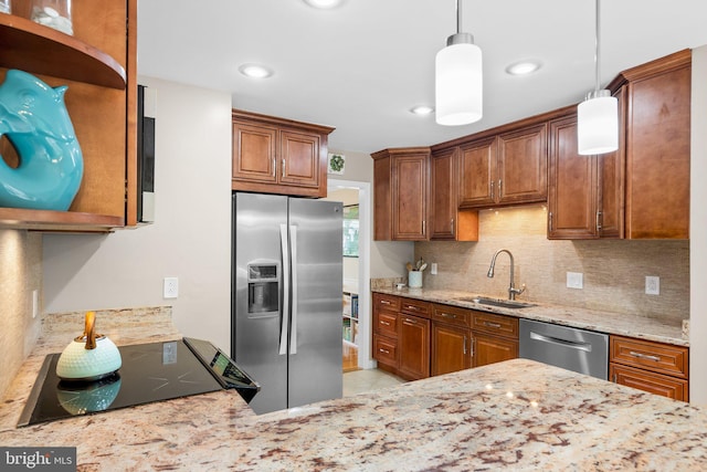 kitchen featuring tasteful backsplash, light stone counters, appliances with stainless steel finishes, brown cabinetry, and a sink