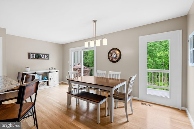 dining space featuring visible vents, light wood-style flooring, and baseboards