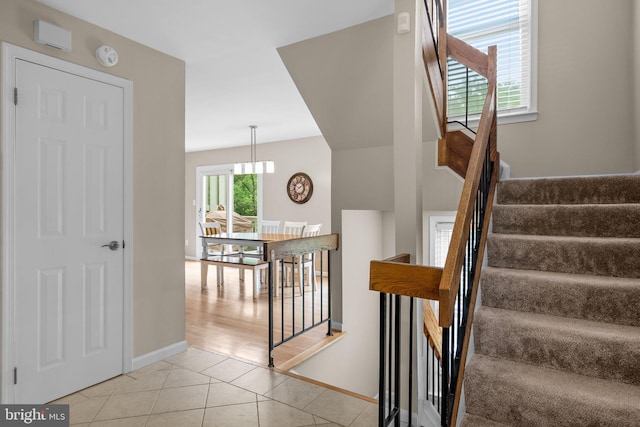 stairs featuring tile patterned floors and baseboards