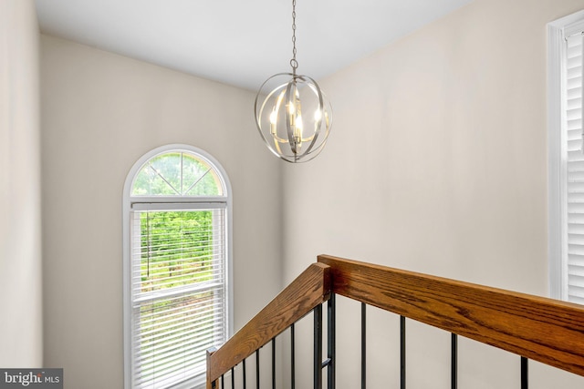 interior space with a chandelier and an upstairs landing