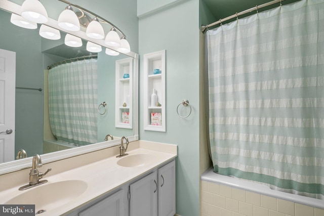 bathroom with double vanity, shower / bath combo, and a sink