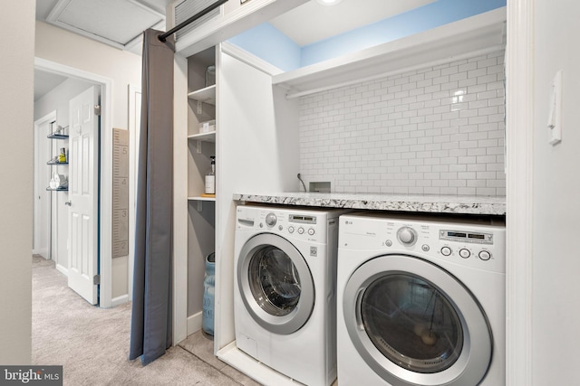 laundry room with light colored carpet, washing machine and dryer, and laundry area