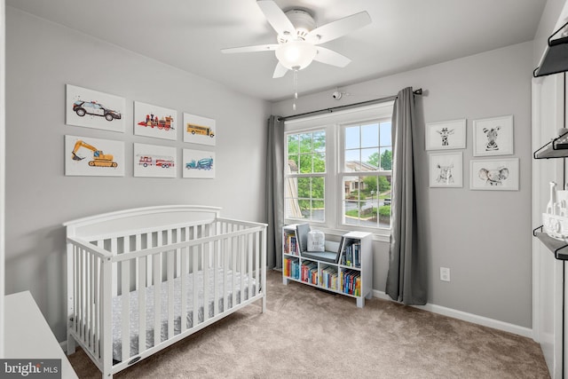 bedroom featuring a ceiling fan, baseboards, a nursery area, and carpet flooring