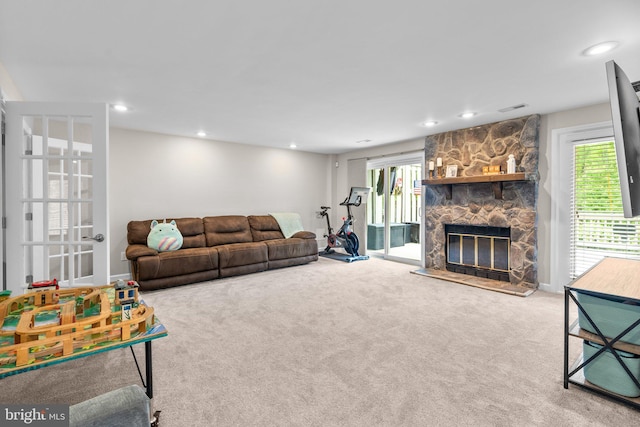 carpeted living area with recessed lighting, visible vents, plenty of natural light, and a fireplace