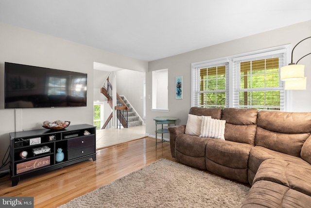 living area featuring stairway and wood finished floors