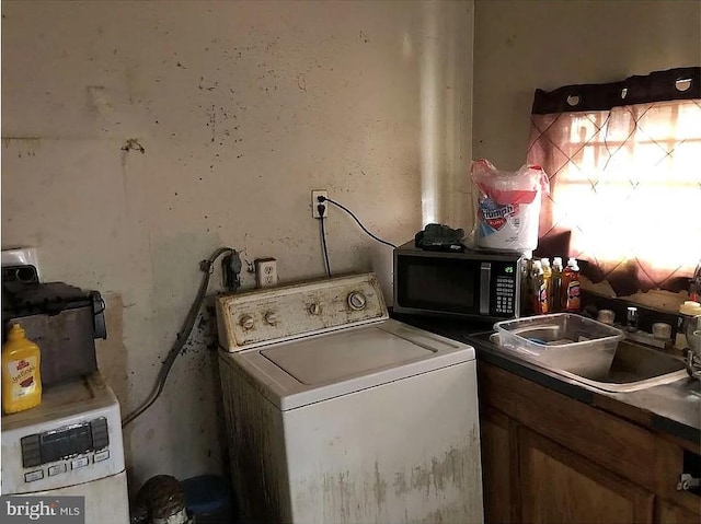 clothes washing area with washer / dryer and a sink