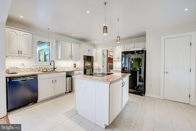 kitchen featuring black appliances, a sink, decorative light fixtures, light stone counters, and a center island