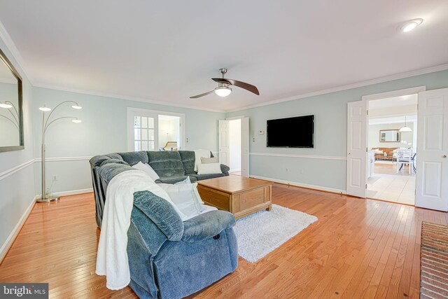 living area with light wood finished floors, crown molding, and baseboards