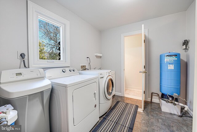 washroom with baseboards, laundry area, and washer and clothes dryer