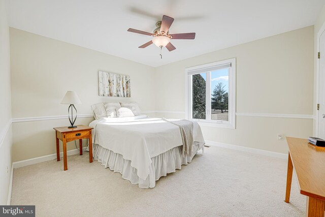 bedroom with light carpet, ceiling fan, and baseboards