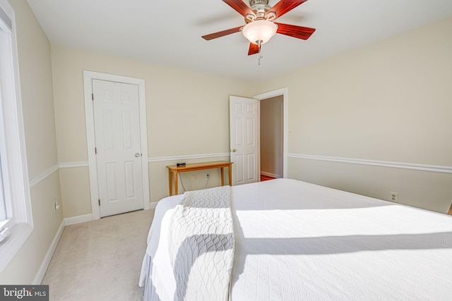 bedroom with ceiling fan, baseboards, and light carpet