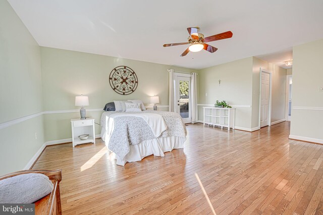 bedroom featuring light wood-type flooring, baseboards, a ceiling fan, and access to outside