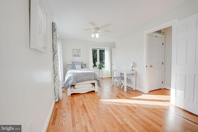 bedroom featuring ceiling fan, baseboards, and light wood-style flooring