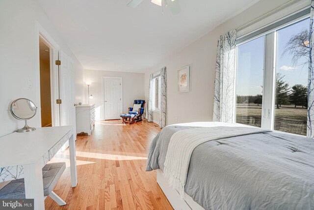 bedroom featuring access to exterior, light wood-style flooring, and a ceiling fan