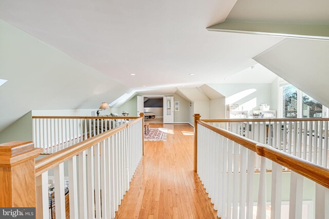 hallway with lofted ceiling and light wood-style flooring