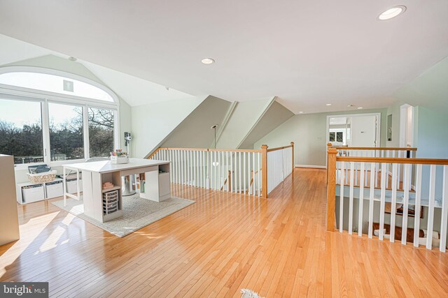 interior space with vaulted ceiling, an upstairs landing, recessed lighting, and wood-type flooring