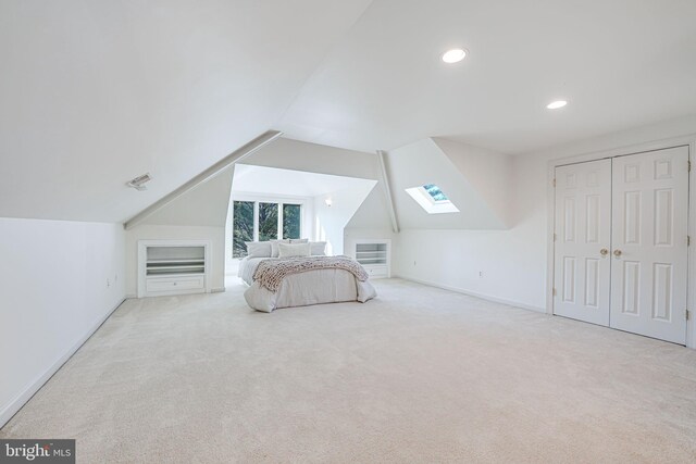 unfurnished bedroom featuring recessed lighting, vaulted ceiling with skylight, baseboards, and carpet floors