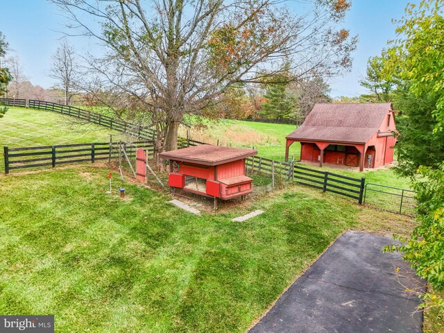 view of yard with a rural view and an outdoor structure