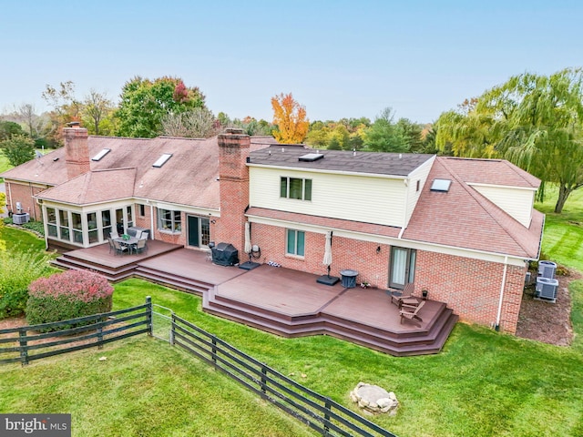 back of house with a deck, a yard, fence private yard, and a chimney