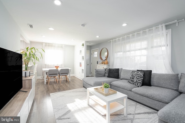 living area featuring recessed lighting, visible vents, light wood finished floors, and baseboards