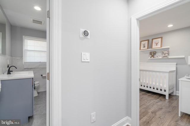 bathroom with visible vents, toilet, recessed lighting, wood finished floors, and vanity