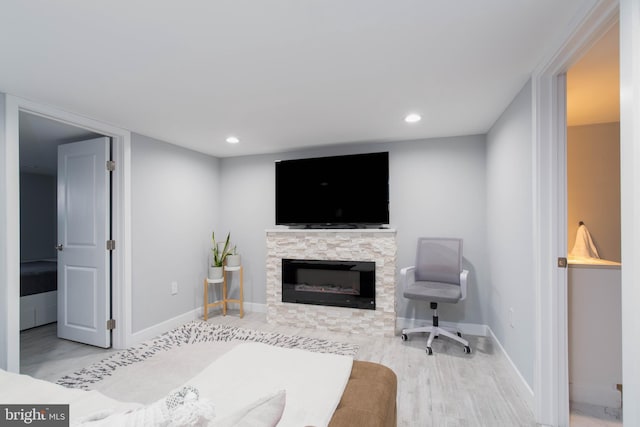 bedroom featuring recessed lighting, baseboards, a stone fireplace, and wood finished floors