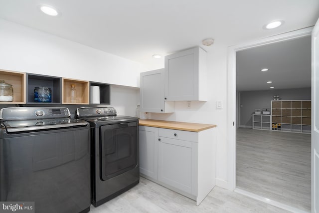 laundry area with light wood-style flooring, recessed lighting, cabinet space, and washing machine and clothes dryer