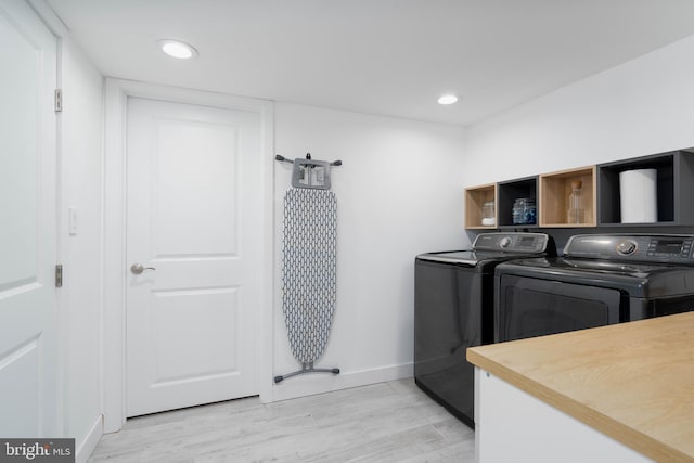 clothes washing area with baseboards, light wood finished floors, washing machine and clothes dryer, laundry area, and recessed lighting