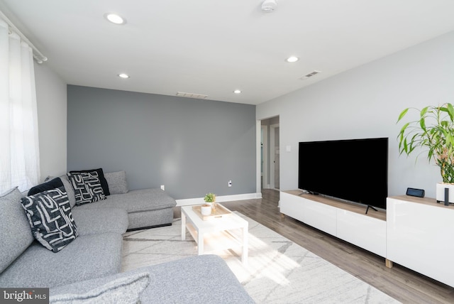 living room featuring recessed lighting, visible vents, baseboards, and wood finished floors