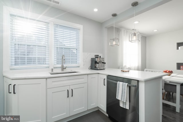 kitchen featuring pendant lighting, dishwasher, light countertops, white cabinetry, and a sink