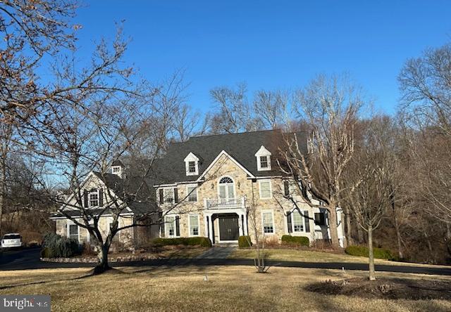 view of front of house featuring a balcony and a front yard