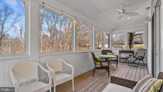 sunroom / solarium featuring wood ceiling, a ceiling fan, and vaulted ceiling