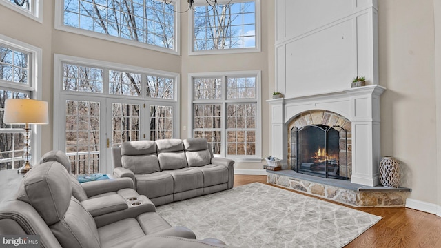 living area featuring wood finished floors, plenty of natural light, a fireplace, and baseboards