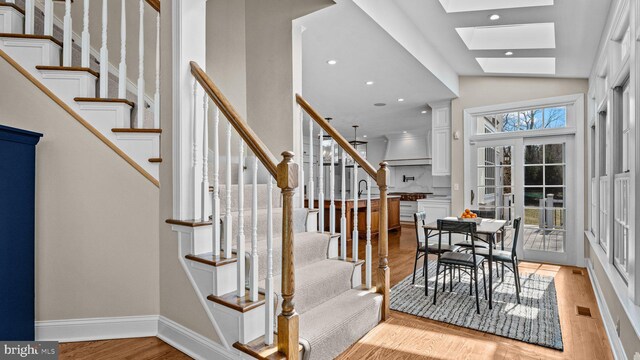 interior space with visible vents, stairway, recessed lighting, a skylight, and light wood-style floors