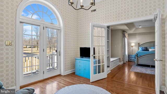 interior space featuring wallpapered walls, wood finished floors, and visible vents