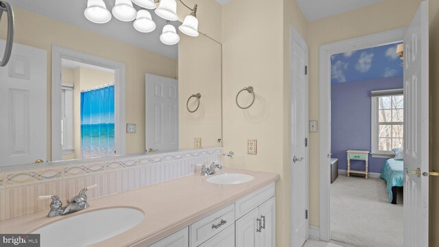 full bathroom featuring double vanity, ensuite bathroom, a chandelier, and a sink