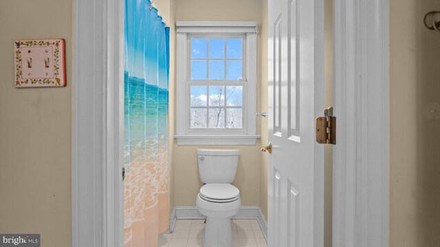 bathroom with tile patterned flooring, toilet, and baseboards