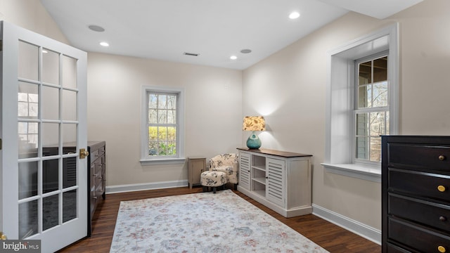 living area featuring visible vents, baseboards, and dark wood-style flooring