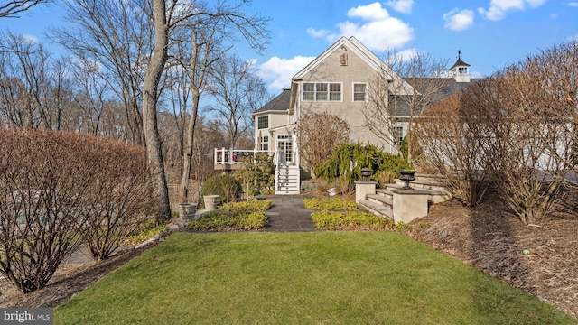 view of front facade with stairway, a front lawn, and stucco siding