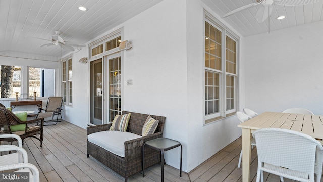 wooden terrace featuring outdoor dining area and ceiling fan