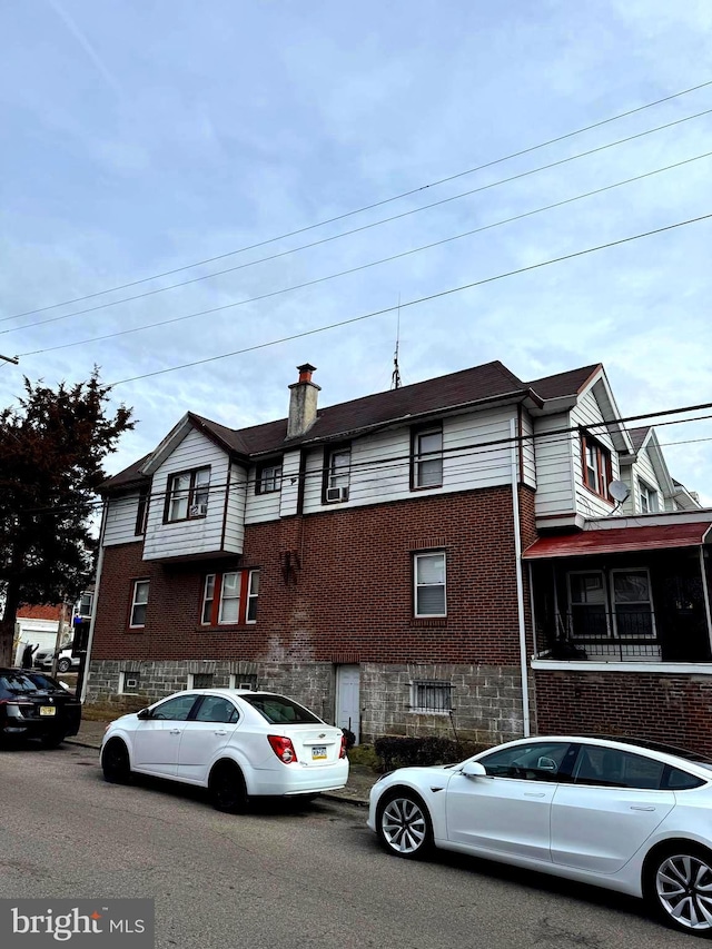view of property with brick siding and a chimney