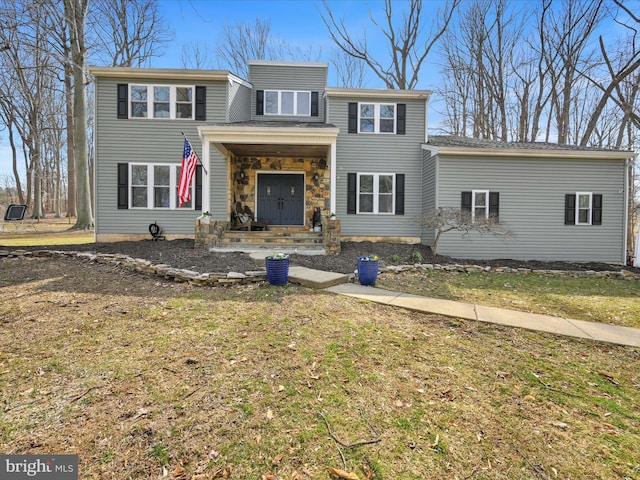 view of front of house with a front yard and stone siding