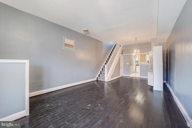1636 N Bentalou St, Baltimore, MD 21216 - unfurnished living room featuring a notable chandelier, stairs, baseboards, and dark wood-style flooring
