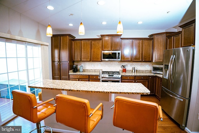 kitchen featuring tasteful backsplash, recessed lighting, hanging light fixtures, appliances with stainless steel finishes, and dark wood-type flooring