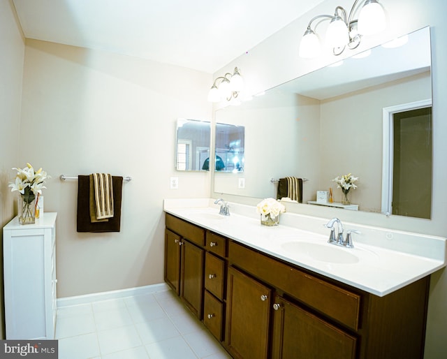 bathroom featuring double vanity, baseboards, a sink, and tile patterned floors