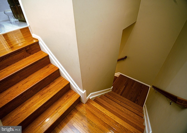 stairway featuring hardwood / wood-style flooring and baseboards