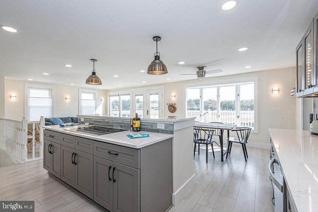 kitchen featuring light wood finished floors, recessed lighting, black electric stovetop, and gray cabinetry